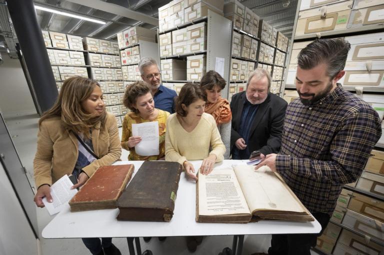Onderzoekers, museummensen en schrijver Norbert Peeters (r) buigen zich over een eeuwenoud boek